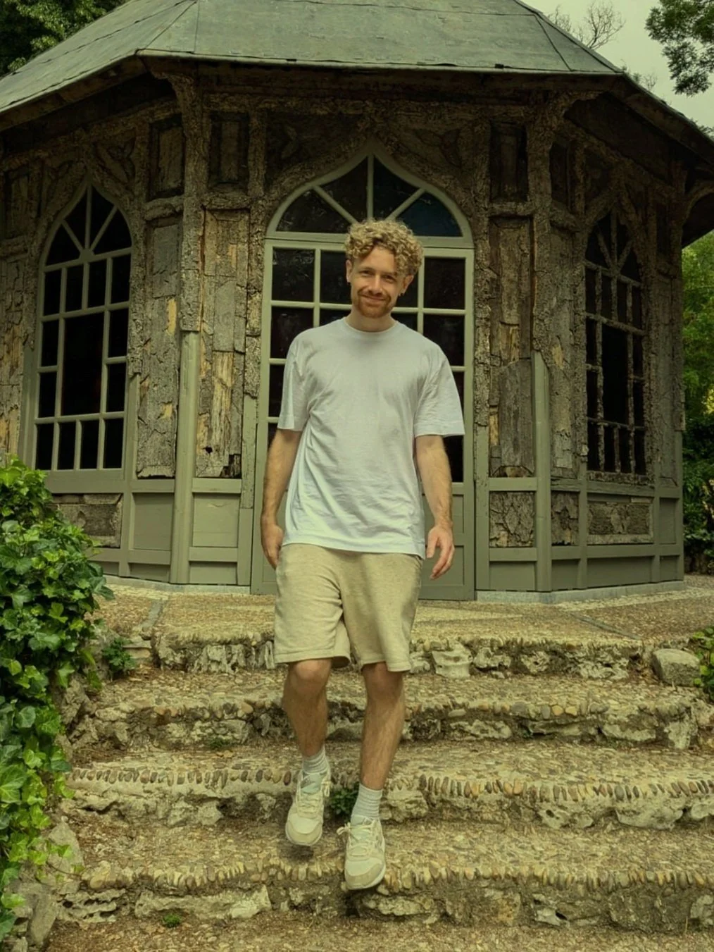 Tom Mortimer standing on stone steps outside a garden building